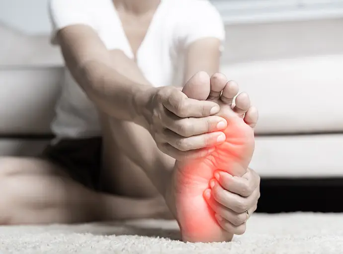 woman feeling pain in her foot