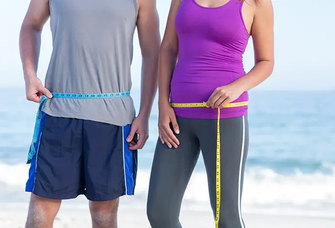 Couple measuring their waists