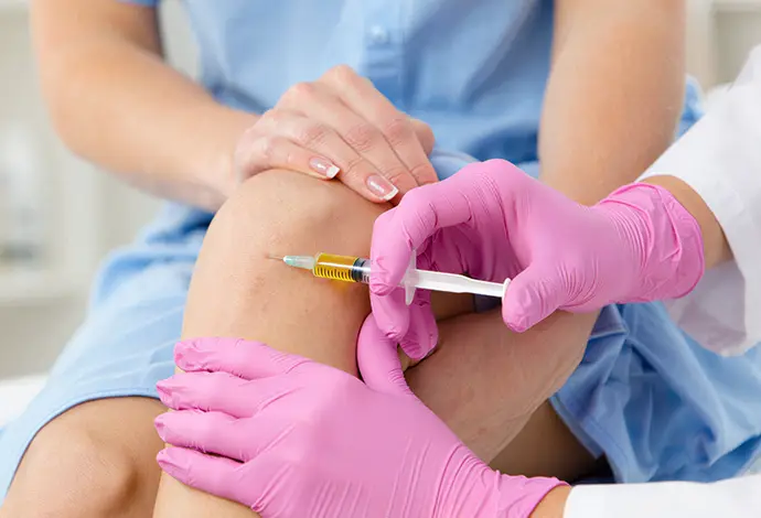 platelet rich plasma injection into female patient’s knee joint for osteoarthritis treatment pain relief and cartilage regeneration during PRP therapy